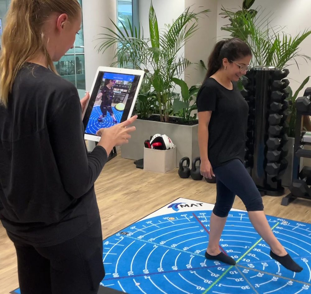 Podiatrist filming a movement assessment on an iPad in the clinic gym