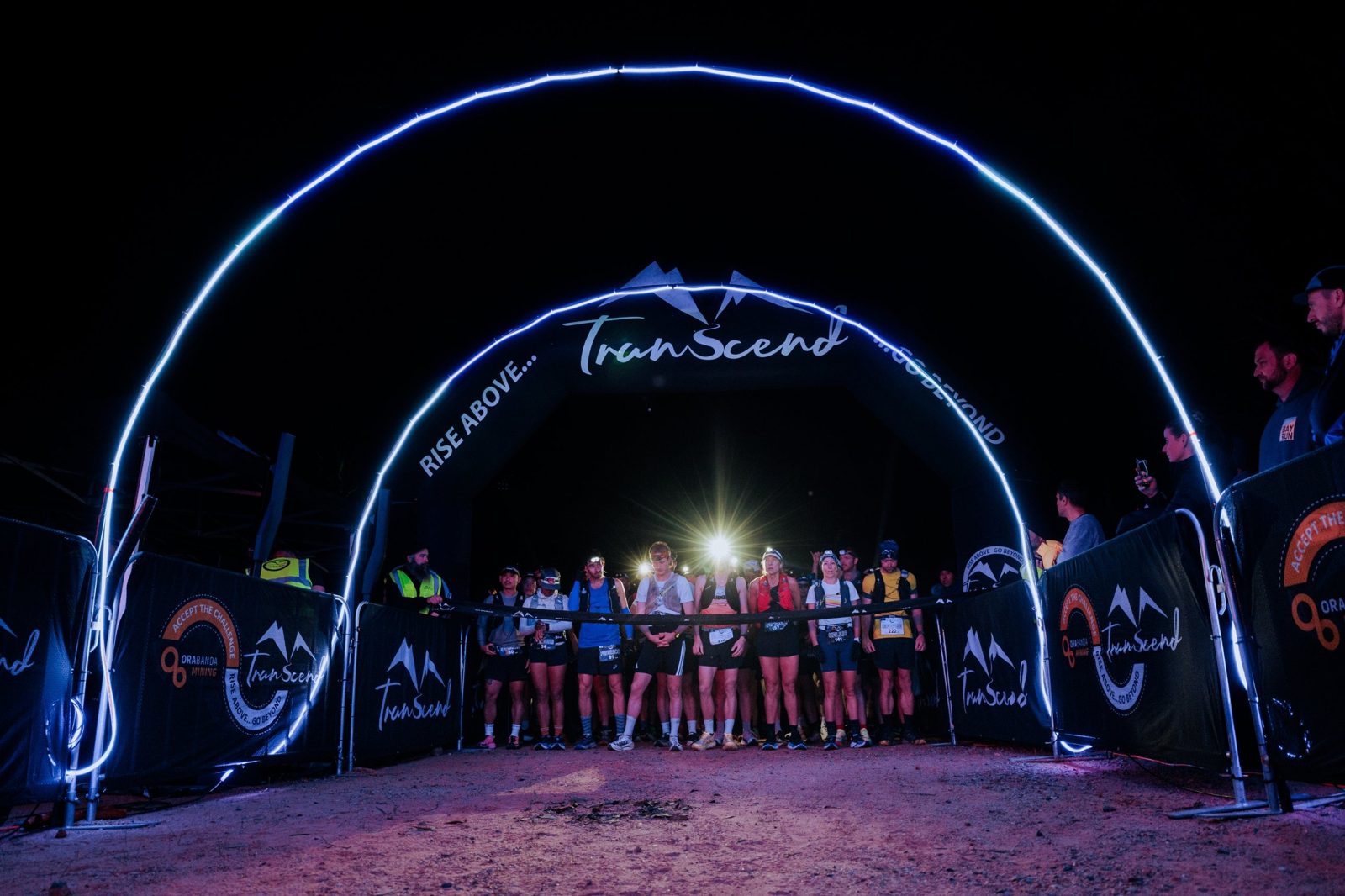 Trail runners with head torches at the Transcend Trails start line at night